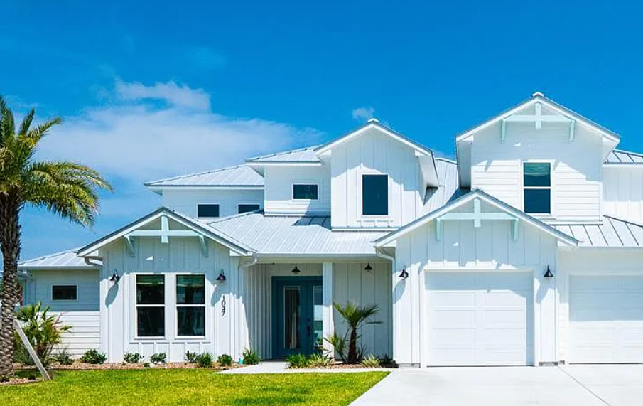 Front of the Islands of Rockport Home. White Exterior with palm tree on the left hand side. 